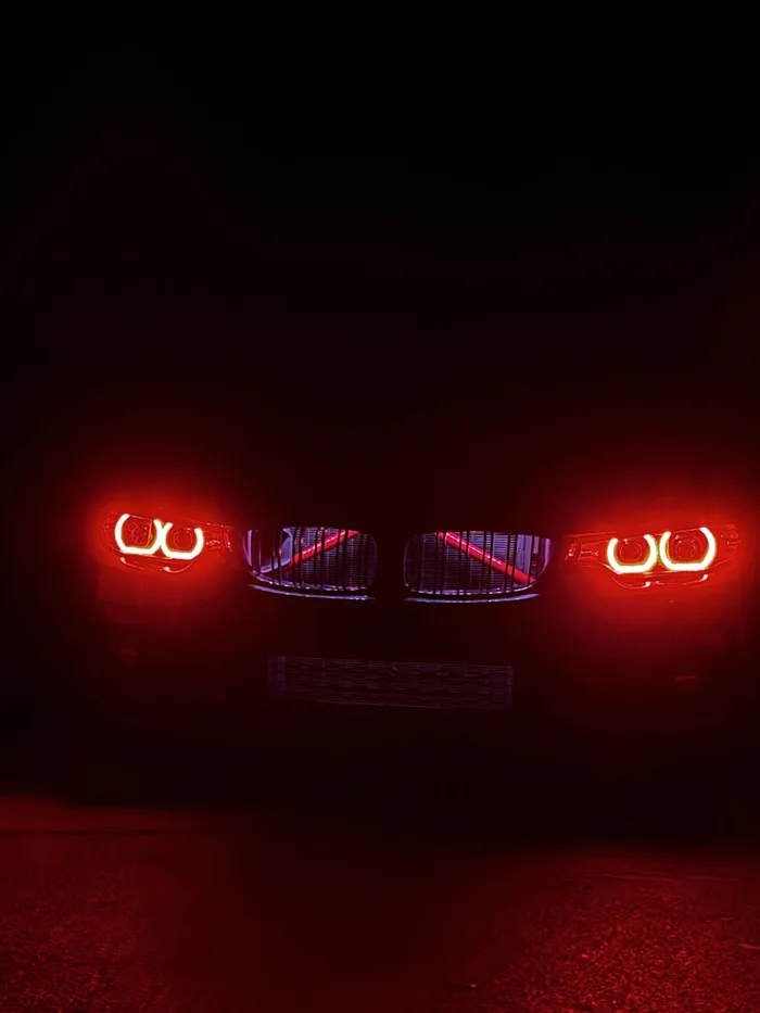 BMW-Front bei Nacht mit rot leuchtenden Angel Eyes