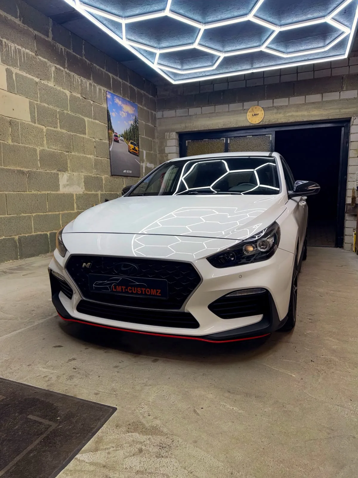 Weißer Hyundai i30 N unter der LED-Wabenbeleuchtung in der Werkstatt in Harthausen